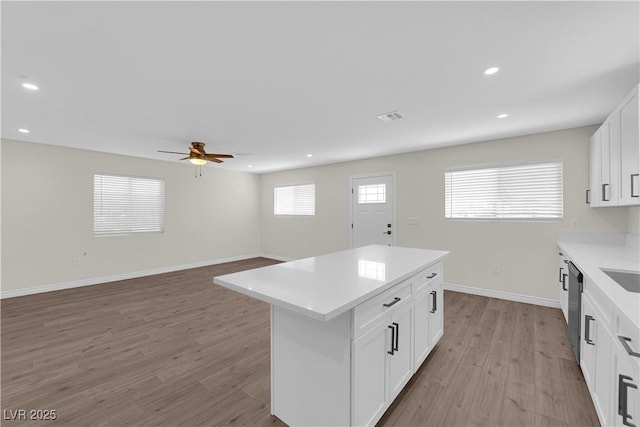 952 Balzar Ave, Las Vegas, NV 89106 - kitchen with a kitchen island, light wood finished floors, light countertops, recessed lighting, and white cabinets