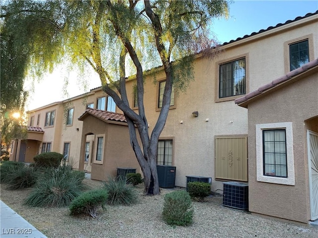 2121 Hussium Hills St Unit 107, Las Vegas, NV 89108 - view of side of property with cooling unit, a tiled roof, and stucco siding
