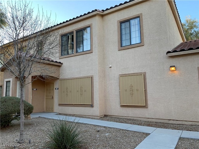 2121 Hussium Hills St Unit 107, Las Vegas, NV 89108 - view of front facade with a tiled roof and stucco siding