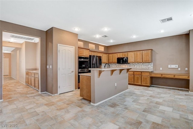 10608 Trussell St, Las Vegas, NV 89141 - kitchen with black appliances, stone finish floors, a breakfast bar area, light countertops, and backsplash