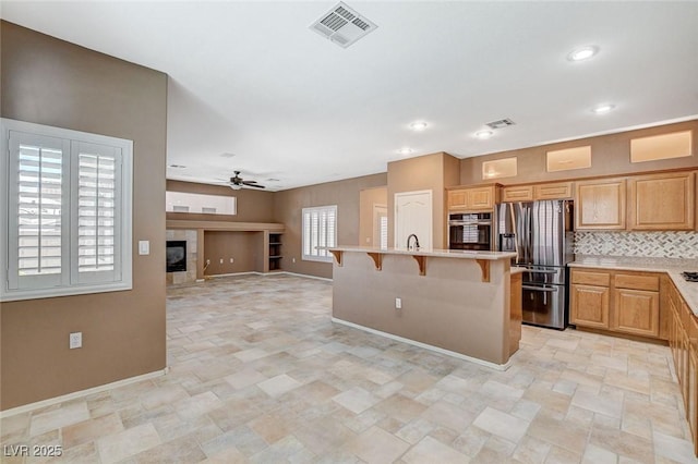 10608 Trussell St, Las Vegas, NV 89141 - kitchen with stainless steel appliances, a kitchen breakfast bar, stone finish floors, light countertops, and open floor plan