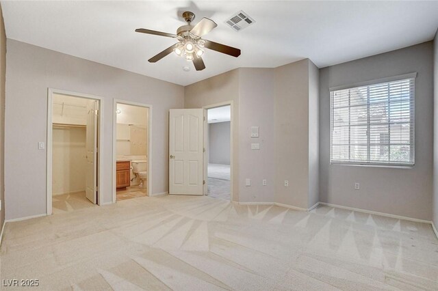 10608 Trussell St, Las Vegas, NV 89141 - unfurnished bedroom featuring light colored carpet, a walk in closet, ensuite bath, and a ceiling fan
