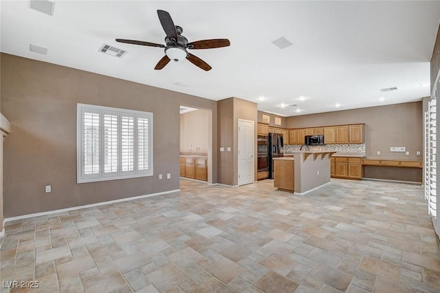 10608 Trussell St, Las Vegas, NV 89141 - kitchen featuring open floor plan, a ceiling fan, stainless steel microwave, light stone finish floors, and light countertops