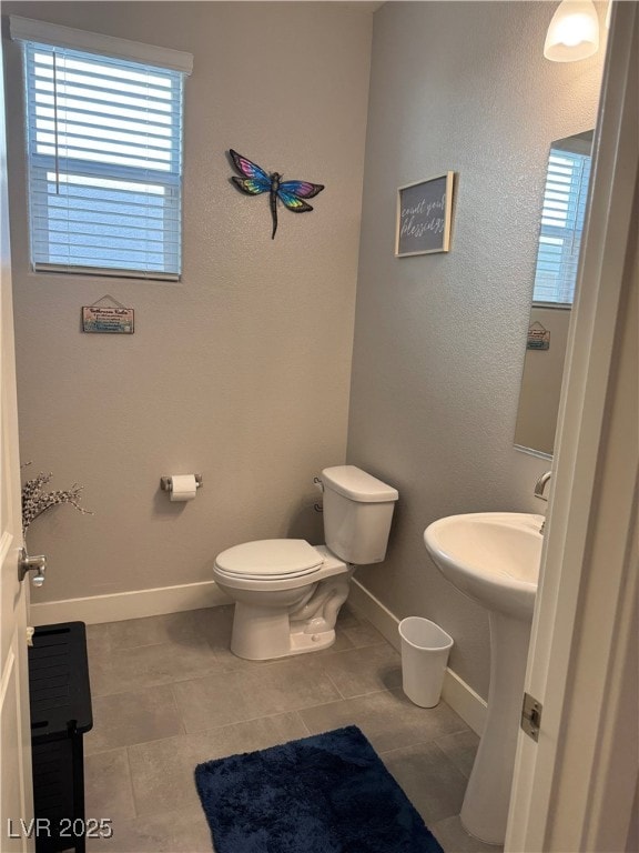 7855 Skyler Falls Ln, North Las Vegas, NV 89084 - half bathroom featuring plenty of natural light, toilet, tile patterned flooring, and baseboards