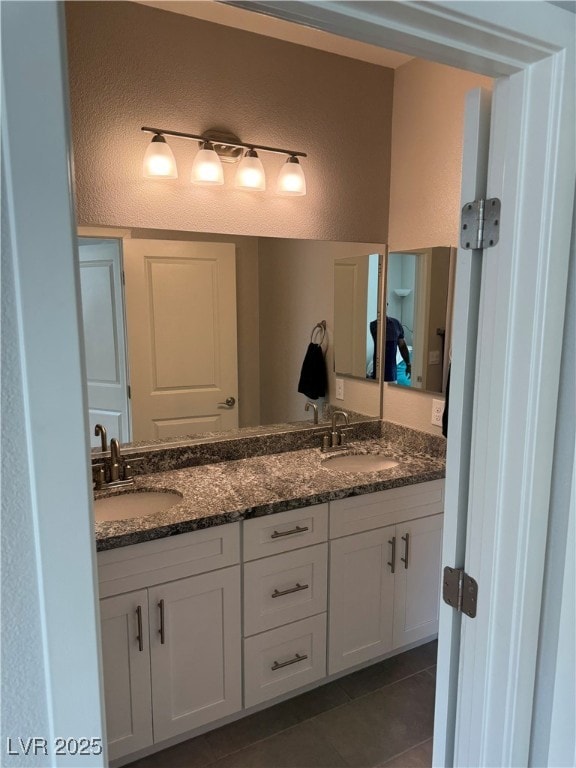 7855 Skyler Falls Ln, North Las Vegas, NV 89084 - bathroom featuring a textured wall, double vanity, and tile patterned flooring