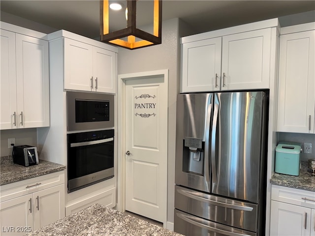 7855 Skyler Falls Ln, North Las Vegas, NV 89084 - kitchen with appliances with stainless steel finishes, white cabinetry, and dark stone counters