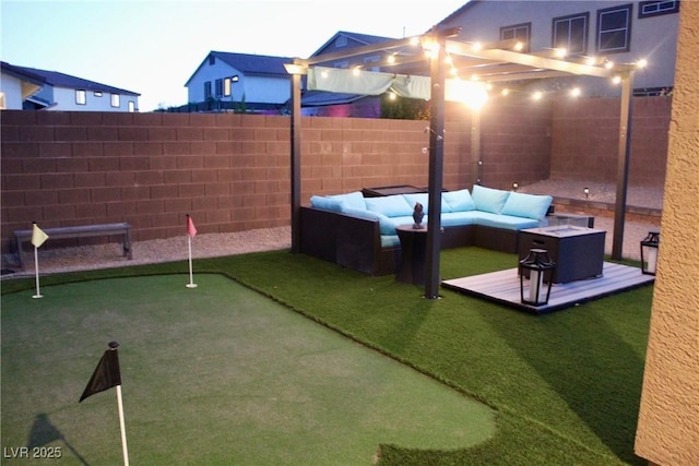 7855 Skyler Falls Ln, North Las Vegas, NV 89084 - fenced backyard with a putting green, an outdoor hangout area, and a wooden deck