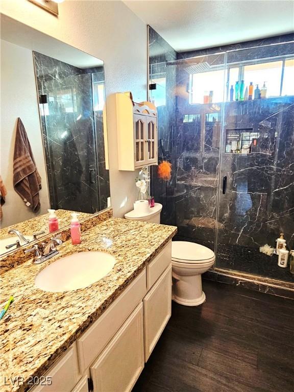1482 Flintrock Rd, Henderson, NV 89014 - full bathroom with wood finished floors, vanity, a marble finish shower, and toilet