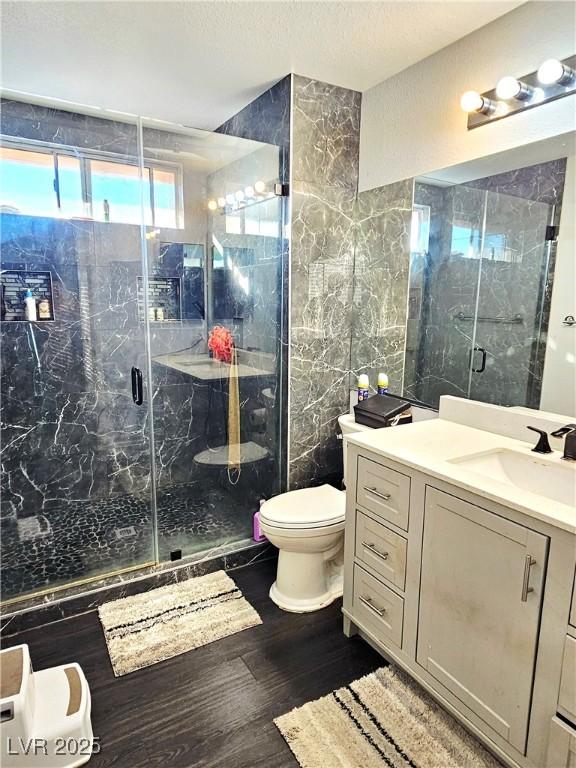 1482 Flintrock Rd, Henderson, NV 89014 - full bath with vanity, wood finished floors, toilet, a marble finish shower, and tile walls