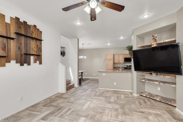 6581 Netherseal Ave, Las Vegas, NV 89139 - kitchen featuring a ceiling fan, stainless steel microwave, baseboards, light brown cabinetry, and a peninsula