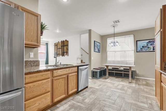 6581 Netherseal Ave, Las Vegas, NV 89139 - kitchen featuring stainless steel appliances, a sink, a chandelier, baseboards, and pendant lighting