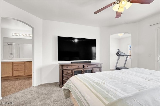 6581 Netherseal Ave, Las Vegas, NV 89139 - bedroom with arched walkways, light colored carpet, ensuite bath, ceiling fan, and baseboards