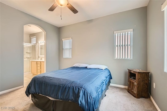 9303 Gilcrease Ave Unit 1002, Las Vegas, NV 89149 - bedroom featuring multiple windows, light carpet, baseboards, and ensuite bath