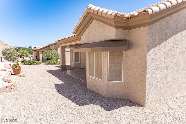 2501 Maddington Dr, Las Vegas, NV 89134 - view of home's exterior with stucco siding, a patio, and a tile roof