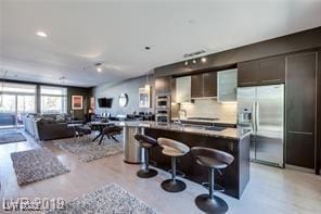 8925 W Flamingo Rd Unit 117, Las Vegas, NV 89147 - kitchen featuring stainless steel refrigerator with ice dispenser, a kitchen bar, open floor plan, modern cabinets, and a center island with sink