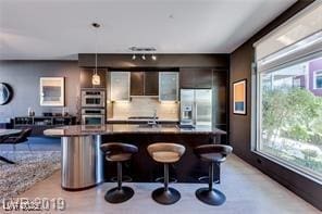 8925 W Flamingo Rd Unit 117, Las Vegas, NV 89147 - bar featuring stainless steel appliances, plenty of natural light, pendant lighting, and tasteful backsplash