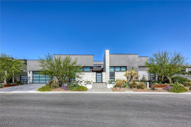 787 Keyland St, Las Vegas, NV 89138 - contemporary home with stucco siding, a garage, stone siding, and driveway