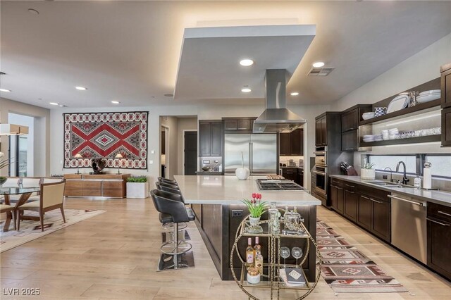 787 Keyland St, Las Vegas, NV 89138 - kitchen featuring appliances with stainless steel finishes, island range hood, a sink, dark brown cabinets, and light countertops