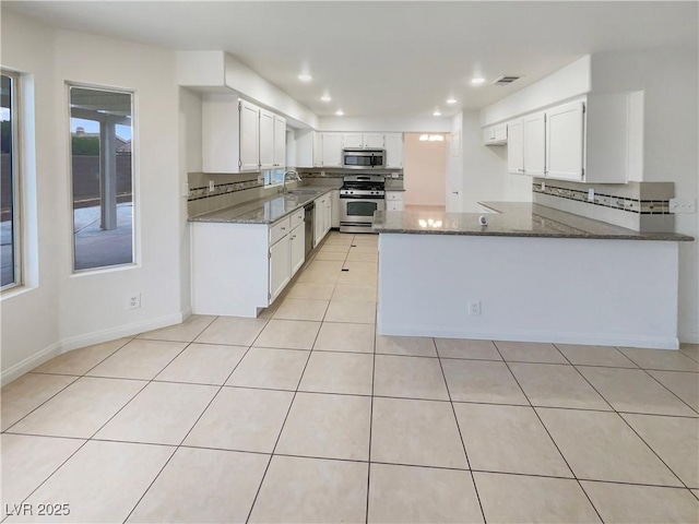 6120 Desert Haven Rd, Las Vegas, NV 89130 - kitchen featuring stainless steel appliances, a sink, dark stone counters, a peninsula, and recessed lighting