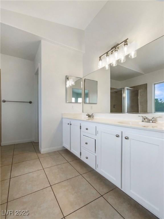 6120 Desert Haven Rd, Las Vegas, NV 89130 - full bathroom featuring a stall shower, double vanity, tile patterned floors, and baseboards