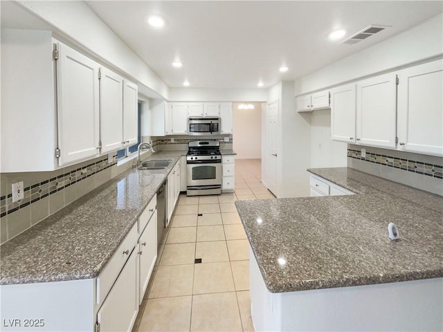 6120 Desert Haven Rd, Las Vegas, NV 89130 - kitchen with stainless steel appliances, a sink, dark stone countertops, decorative backsplash, and light tile patterned flooring