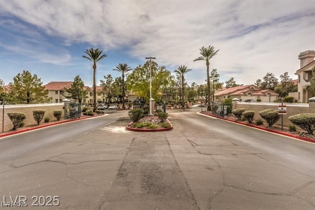 7912 Foxwood Pl Unit 104, Las Vegas, NV 89145 - view of asphalt road with a residential view, a gate, and curbs