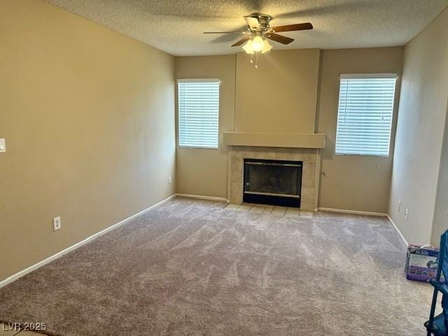 7912 Foxwood Pl Unit 104, Las Vegas, NV 89145 - unfurnished living room with a ceiling fan, a tile fireplace, a textured ceiling, carpet flooring, and baseboards