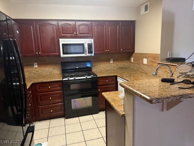 7912 Foxwood Pl Unit 104, Las Vegas, NV 89145 - kitchen featuring black appliances, a peninsula, dark brown cabinets, and light tile patterned floors