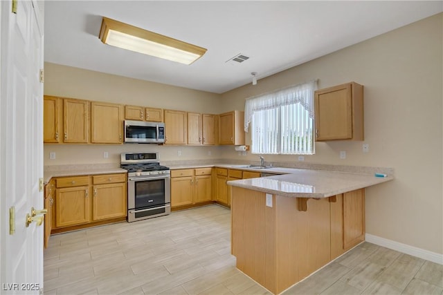 8913 Loggers Mill Ave, Las Vegas, NV 89143 - kitchen with appliances with stainless steel finishes, a peninsula, a sink, and light countertops