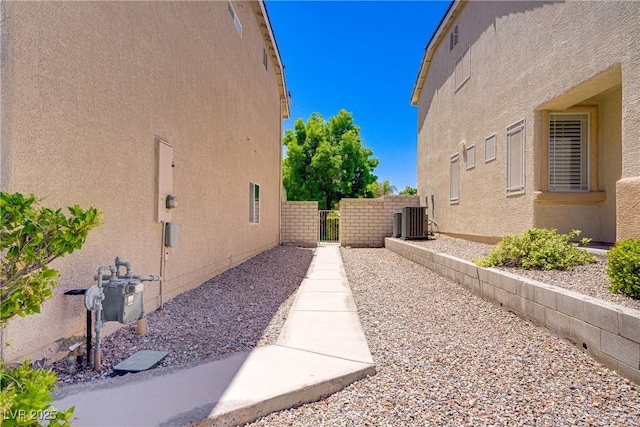 8913 Loggers Mill Ave, Las Vegas, NV 89143 - view of home's exterior with stucco siding, a gate, and cooling unit