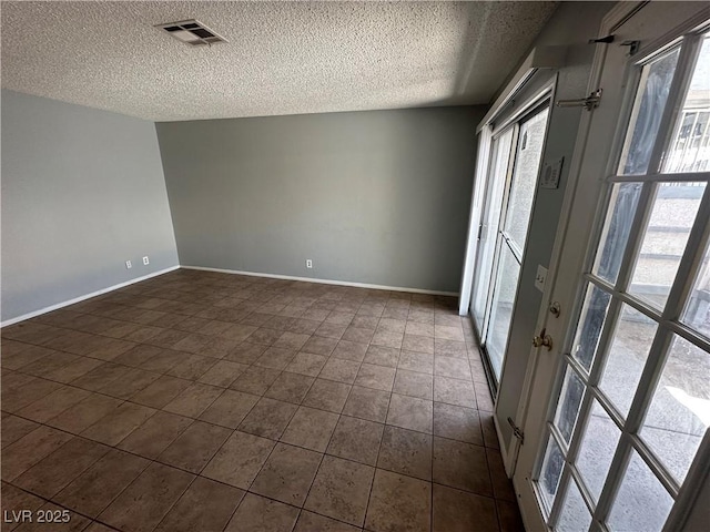 227 N Lamb Blvd Unit A, Las Vegas, NV 89110 - empty room featuring a textured ceiling, baseboards, and dark tile patterned flooring