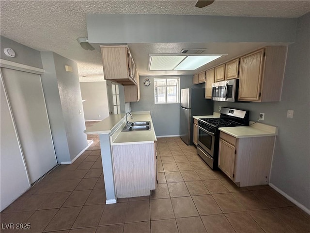 227 N Lamb Blvd Unit A, Las Vegas, NV 89110 - kitchen with stainless steel appliances, a sink, tile patterned flooring, light countertops, and a textured ceiling