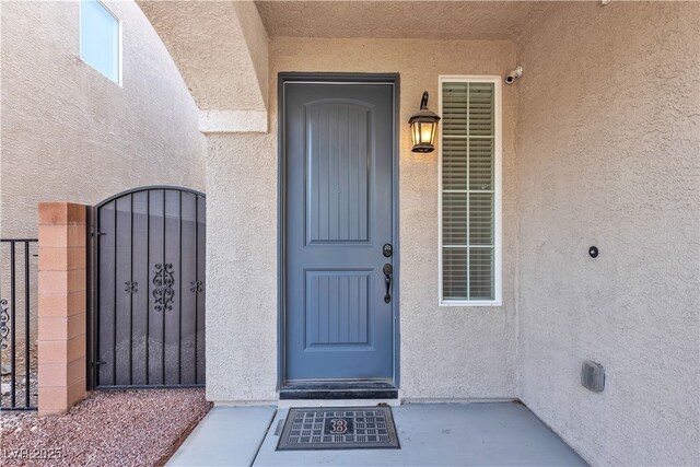 5661 Brimstone Hill Ave, Las Vegas, NV 89141 - doorway to property featuring stucco siding and a gate