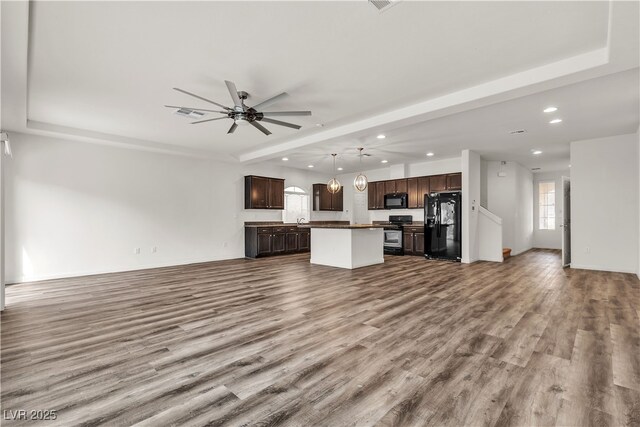 5661 Brimstone Hill Ave, Las Vegas, NV 89141 - unfurnished living room with recessed lighting, wood finished floors, a ceiling fan, baseboards, and a tray ceiling