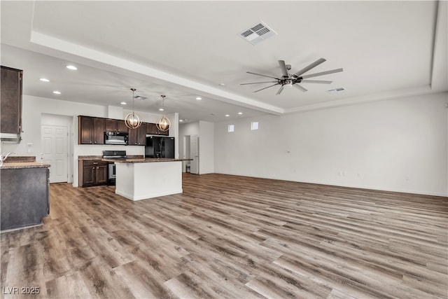 5661 Brimstone Hill Ave, Las Vegas, NV 89141 - kitchen with black appliances, open floor plan, recessed lighting, wood finished floors, and dark brown cabinetry