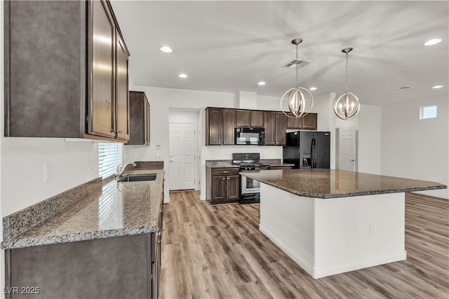 5661 Brimstone Hill Ave, Las Vegas, NV 89141 - kitchen with black appliances, dark brown cabinets, a sink, light wood finished floors, and recessed lighting