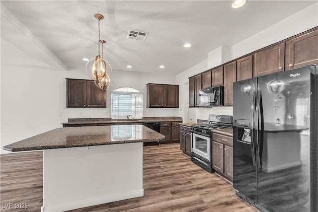 5661 Brimstone Hill Ave, Las Vegas, NV 89141 - kitchen with black appliances, dark brown cabinetry, a kitchen island, dark stone counters, and a chandelier