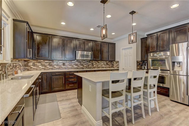 5635 Mesa Mountain Dr, Las Vegas, NV 89135 - kitchen with appliances with stainless steel finishes, a sink, crown molding, a kitchen island, and dark brown cabinetry