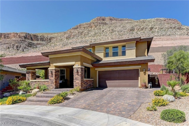 5635 Mesa Mountain Dr, Las Vegas, NV 89135 - prairie-style home featuring stucco siding, a mountain view, an attached garage, decorative driveway, and stone siding
