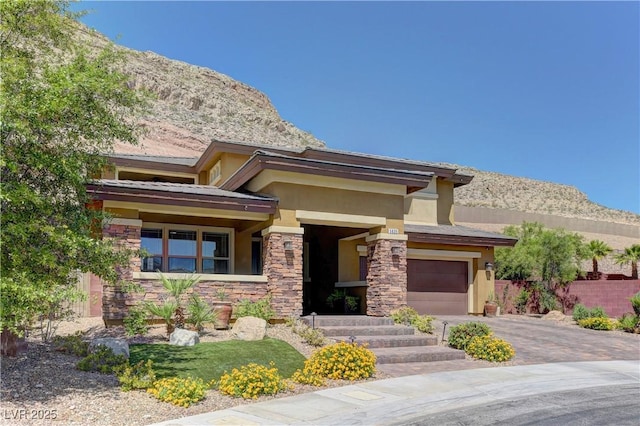 5635 Mesa Mountain Dr, Las Vegas, NV 89135 - view of front of house with stone siding, stucco siding, asphalt driveway, a mountain view, and a garage