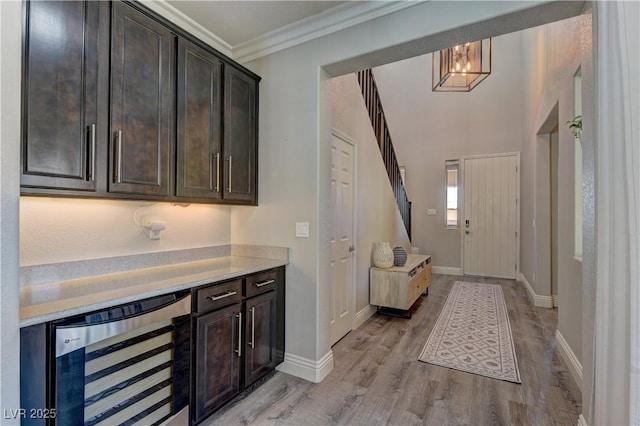 5635 Mesa Mountain Dr, Las Vegas, NV 89135 - bar featuring beverage cooler, light wood finished floors, baseboards, crown molding, and a chandelier