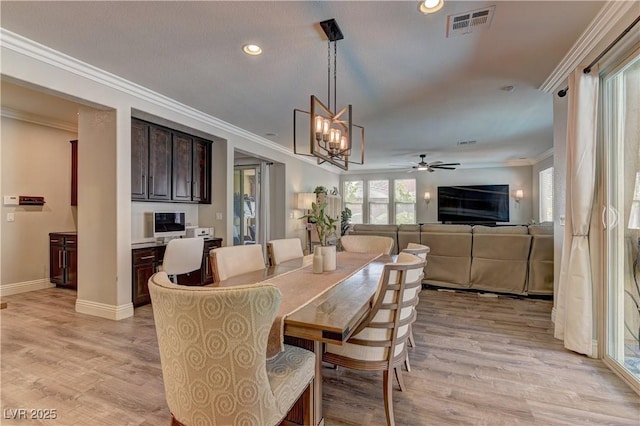 5635 Mesa Mountain Dr, Las Vegas, NV 89135 - dining room featuring recessed lighting, crown molding, light wood-type flooring, a chandelier, and baseboards