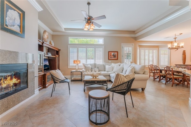 11405 Perugino Dr, Las Vegas, NV 89138 - living room featuring a tray ceiling, a fireplace, crown molding, ceiling fan, and light tile patterned floors