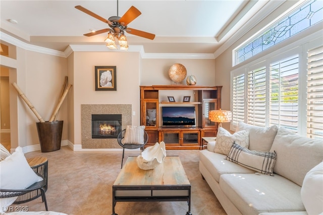 11405 Perugino Dr, Las Vegas, NV 89138 - living area featuring a glass covered fireplace, a ceiling fan, ornamental molding, baseboards, and a raised ceiling