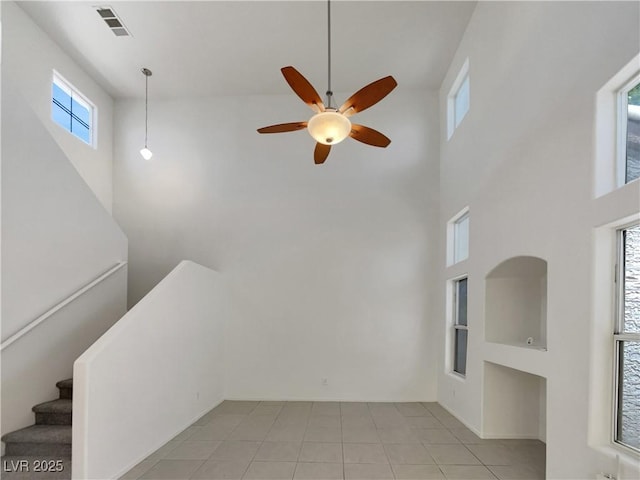 7900 Wood Shadow Ct, Las Vegas, NV 89131 - unfurnished living room featuring a towering ceiling, a ceiling fan, light tile patterned floors, and stairs