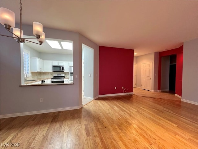 2343 Scotch Lake St, Las Vegas, NV 89134 - unfurnished living room featuring a chandelier, light wood-type flooring, a sink, and baseboards