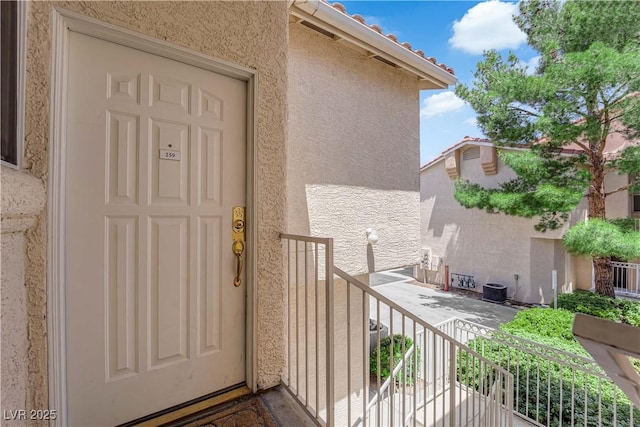 5000 Red Rock St Unit 259, Las Vegas, NV 89118 - doorway to property featuring stucco siding, central air condition unit, a balcony, and a tiled roof