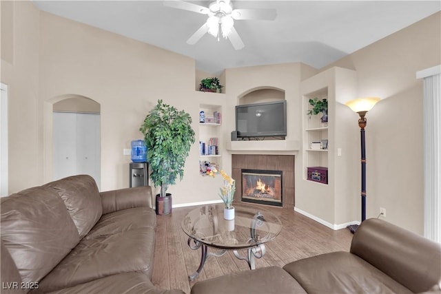 5000 Red Rock St Unit 259, Las Vegas, NV 89118 - living room with ceiling fan, a fireplace, baseboards, built in shelves, and arched walkways
