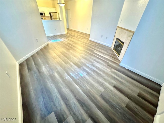 5250 S Rainbow Blvd Unit 2029, Las Vegas, NV 89118 - unfurnished living room with baseboards, light wood-type flooring, and a fireplace
