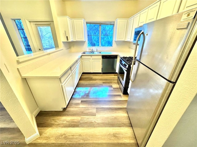 5250 S Rainbow Blvd Unit 2029, Las Vegas, NV 89118 - kitchen featuring stainless steel appliances, light wood-style flooring, a sink, and white cabinetry